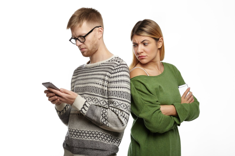 Para w konflikcie – kobieta patrzy z podejrzliwością na telefon partnera. Czy zdrada ma wpływ na wysokość alimentów?